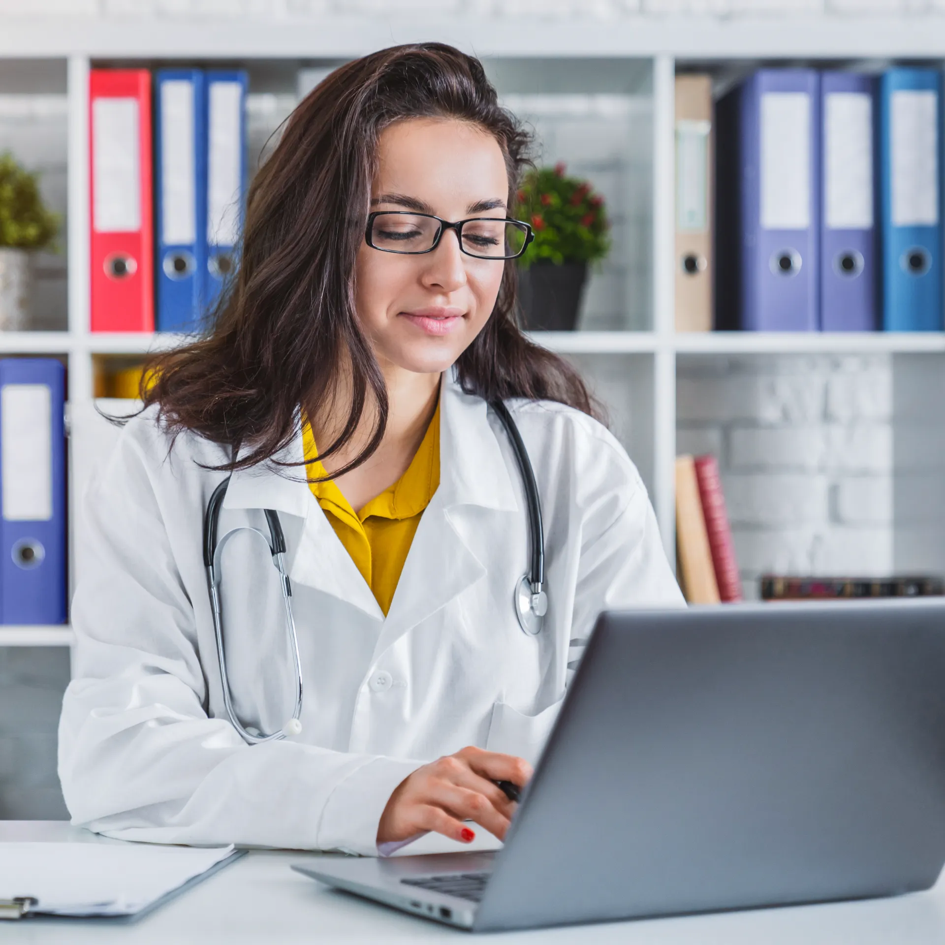 attractive female doctor working on laptop in hosp utc