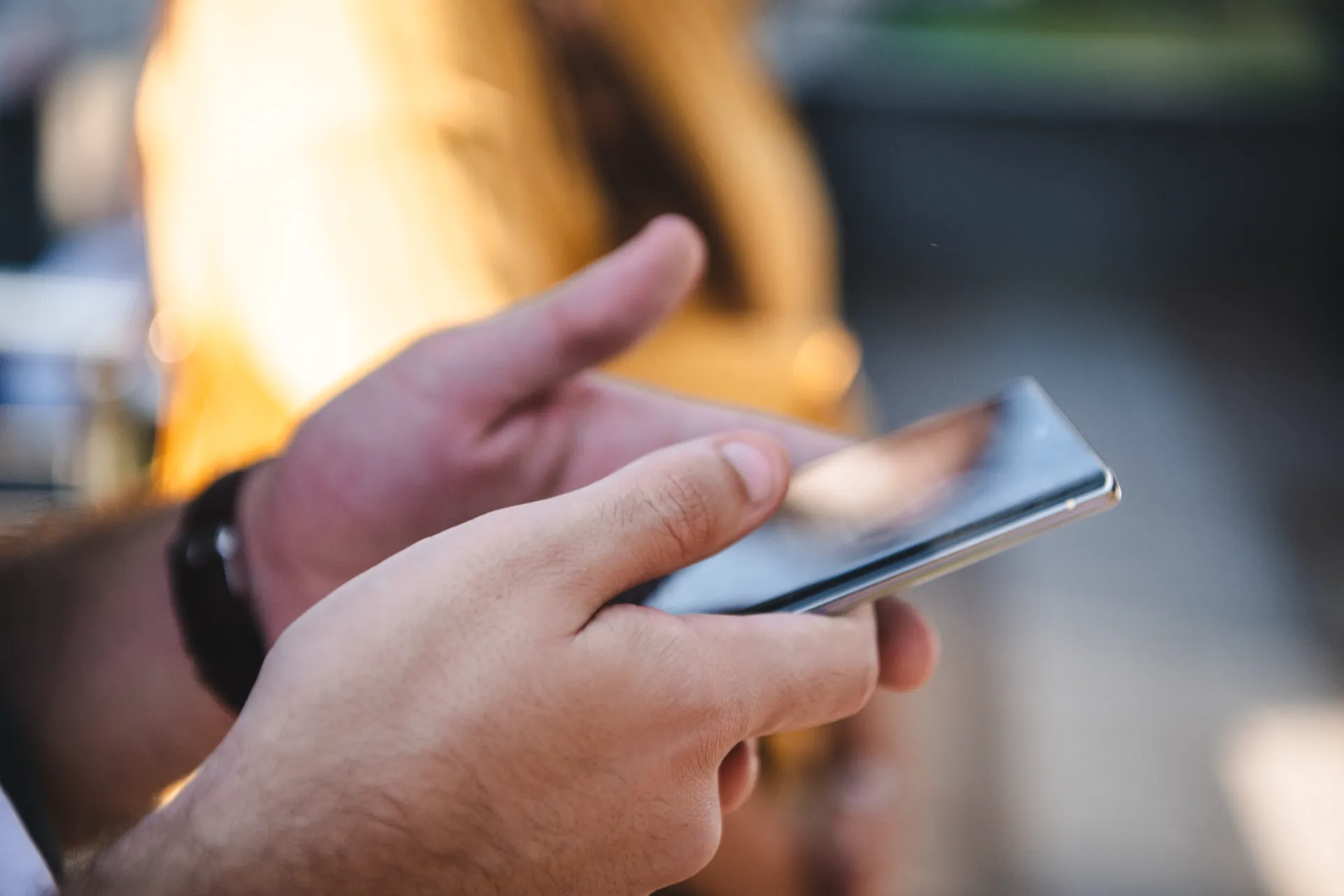 person using smartphone in urban setting utc